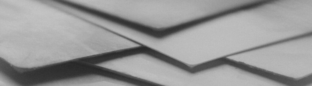 Close-up of overlapping paper layers in grayscale, creating an abstract artistic effect.